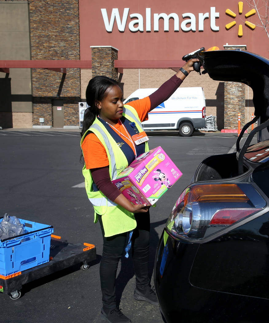 Personal shopper Mety Woldeyes loads a customer's curbside pickup order at Walmart at 7200 Arro ...