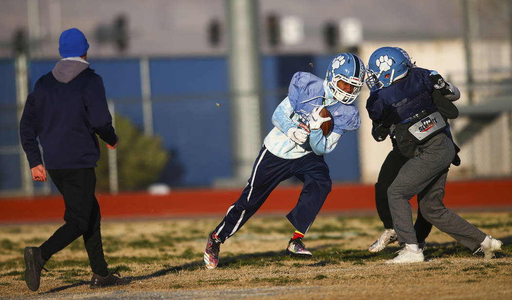 Centennial's Giovanni Monroe runs the ball during football practice at Centennial High School i ...