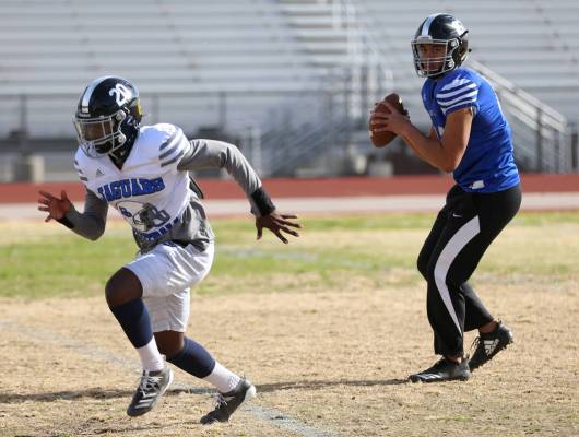 Desert Pines' Rjay Tagataese (15) looks to make a pass to DeAvonte McGee (20) during a team pra ...