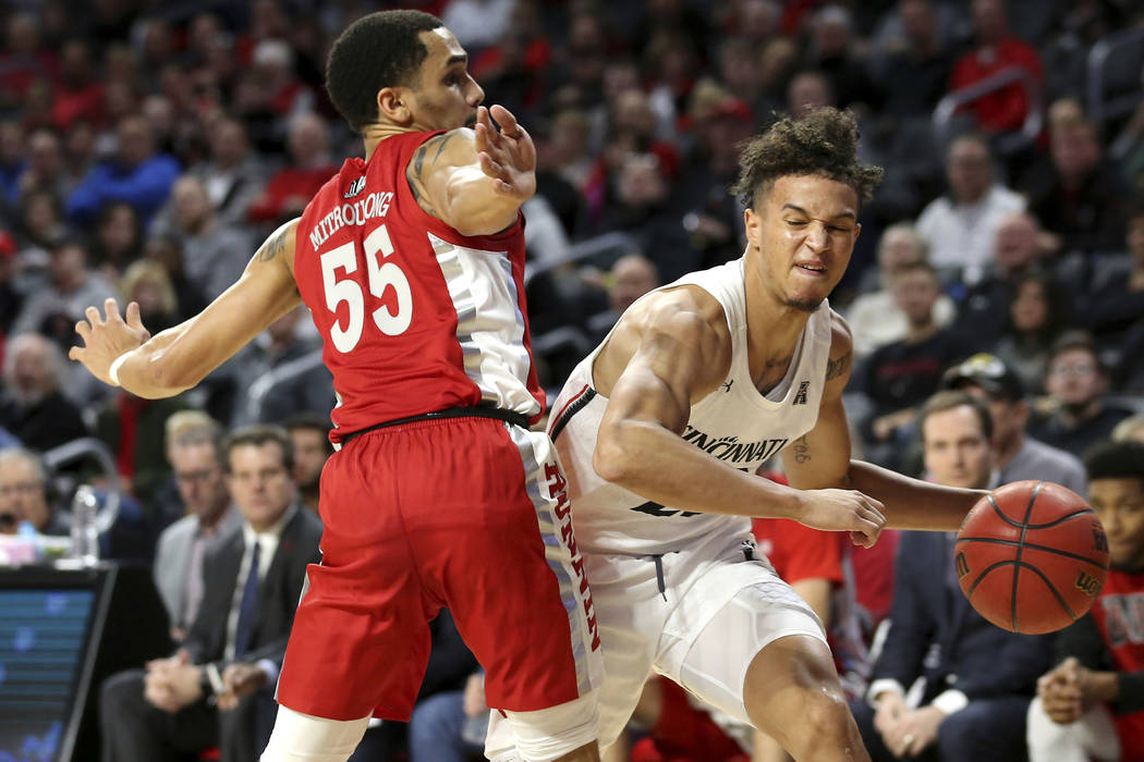 Cincinnati guard Zach Harvey (23) drives to the basket as UNLV guard Elijah Mitrou-Long (55) de ...