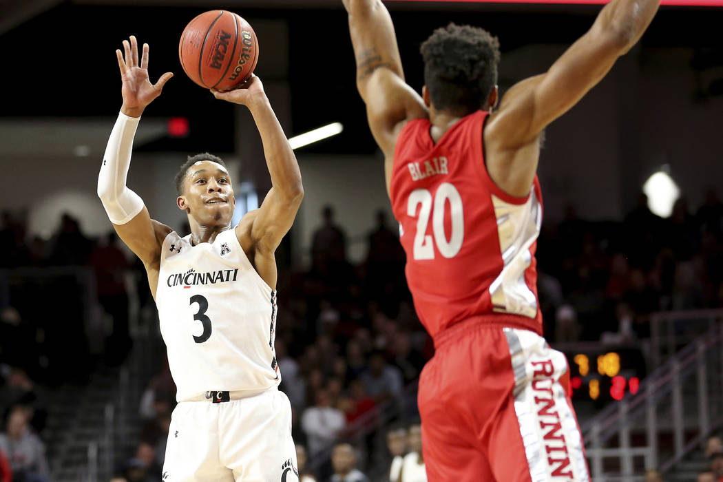 Cincinnati guard Mika Adams-Woods (3) rises for a shot as UNLV forward Nick Blair (20) defends ...