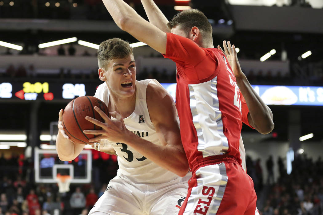 Cincinnati center Chris Vogt (33) eyes the basket as UNLV forward Vitaliy Shibel (22) defends d ...