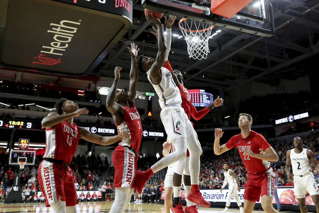 Cincinnati guard Jarron Cumberland (34) drives to the basket as UNLV guard Bryce Hamilton (13) ...