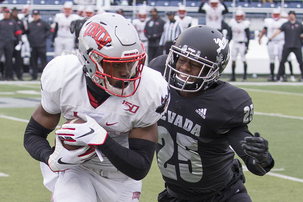 UNLV wide receiver Mekhi Stevenson, left, is hit by Nevada defensive back Daniel Brown (25) in ...