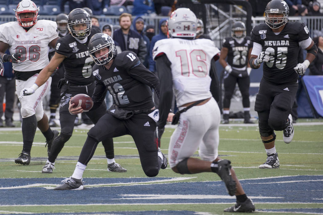 Nevada quarterback Carson Strong (12) cuts back as UNLV linebacker Javin White (16) makes a pla ...