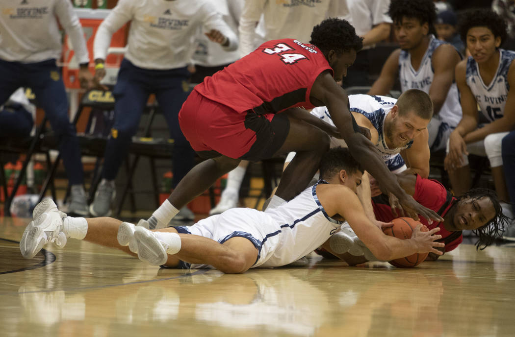 UC-Irvine's guard Isaiah Lee (5) and guard Devin Cole (1) dive for the ball with Louisiana's fo ...