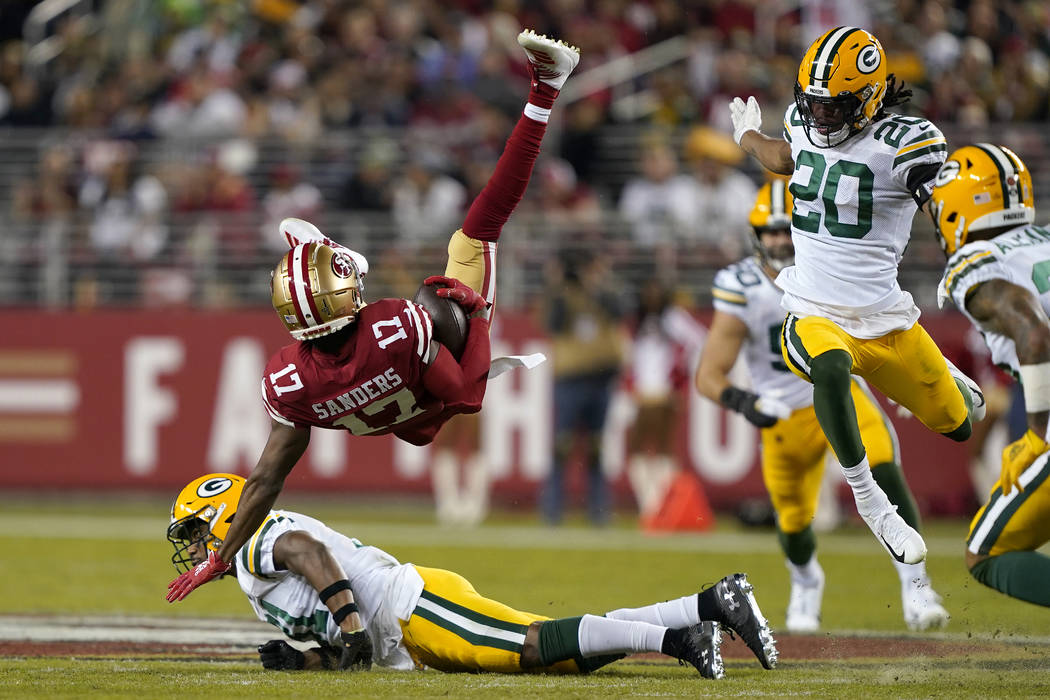 San Francisco 49ers wide receiver Emmanuel Sanders (17) falls backward over Green Bay Packers s ...