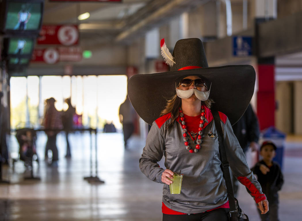 Kim Arrasate in a Hey Reb costume makes her way through the concourse after purchasing a drink ...