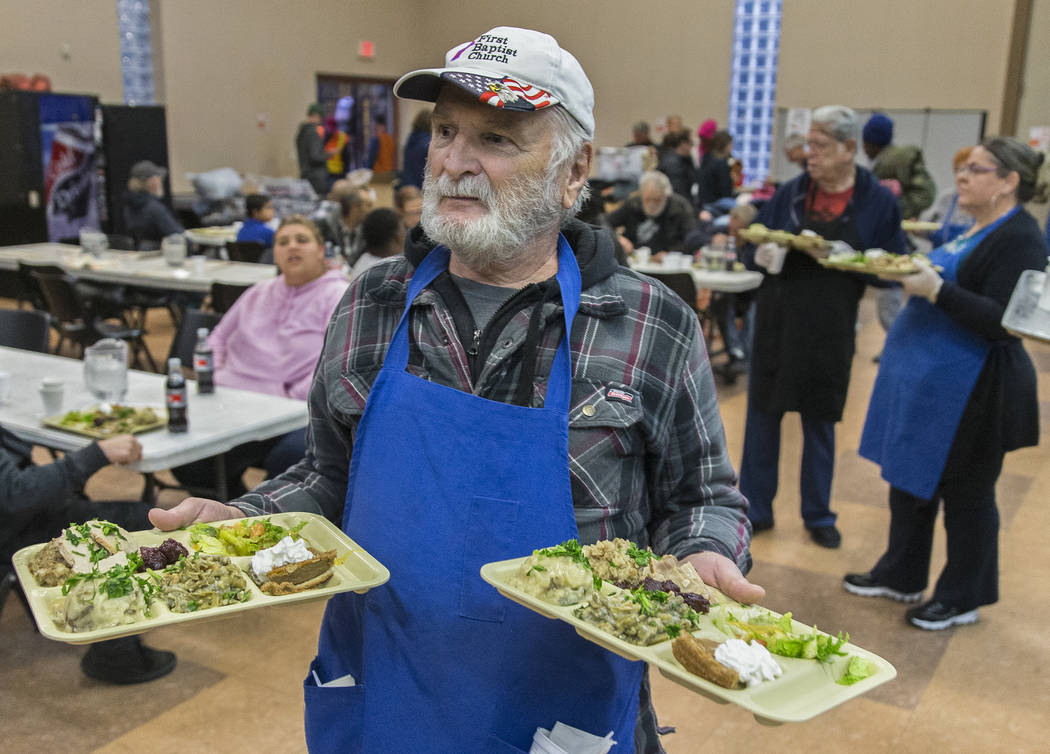 Volunteer Earl Thomas serves trays of food during the Las Vegas Rescue Mission's annual Thanksg ...