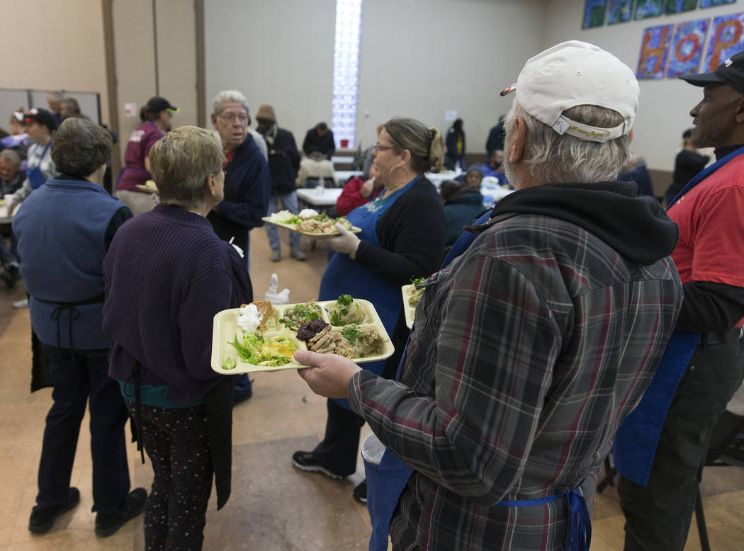 Volunteer Earl Thomas, bottom/right, serves trays of food during the Las Vegas Rescue Mission's ...