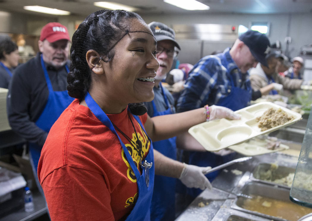 Volunteer Britany Bautista prepares trays of food during the Las Vegas Rescue Mission's annual ...