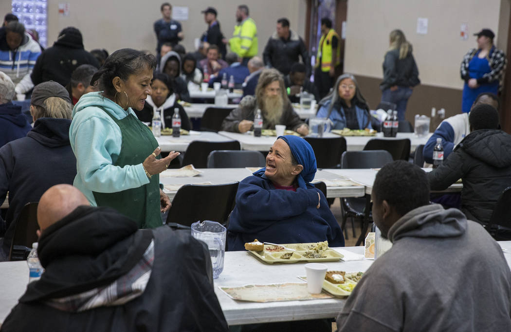 Volunteer Barbara Callahan, top/left, talks with attendees during the Las Vegas Rescue Mission' ...