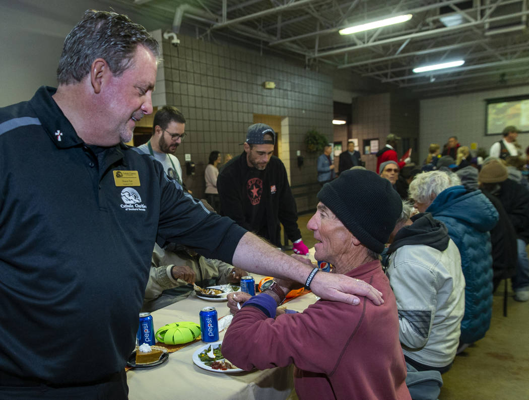 Deacon Tom Roberts, president and CEO of Catholic Charities of Southern Nevada, talks with dine ...