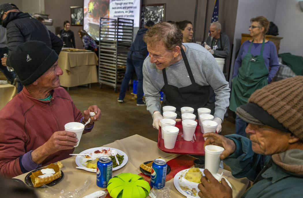 Fred Berkley, center, delivers hot chocolate to diner Jeff Ward, left, and others as Catholic C ...