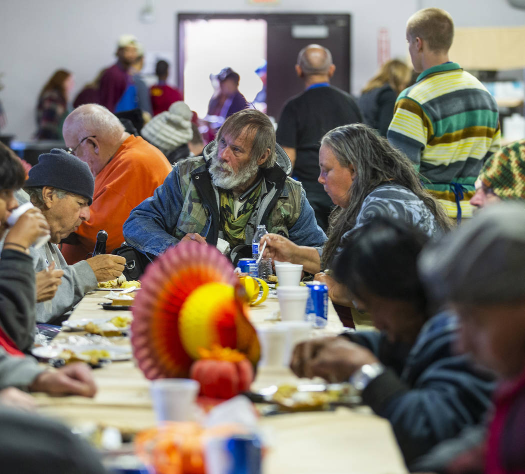 Johnnie Smythe, center, joins others in dining as Catholic Charities of Southern Nevada serves ...