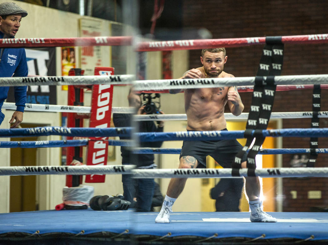 Former two-weight world boxing champion Carl Frampton, center, shadow boxes in the ring with tr ...