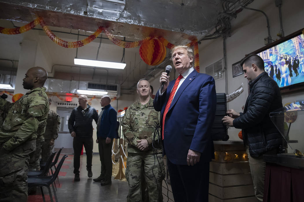 President Donald Trump speaks at a dinning facility during a surprise Thanksgiving Day visit to ...