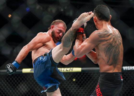 Donald Cerrone, left, kicks Tony Ferguson during their lightweight mixed martial arts bout at U ...