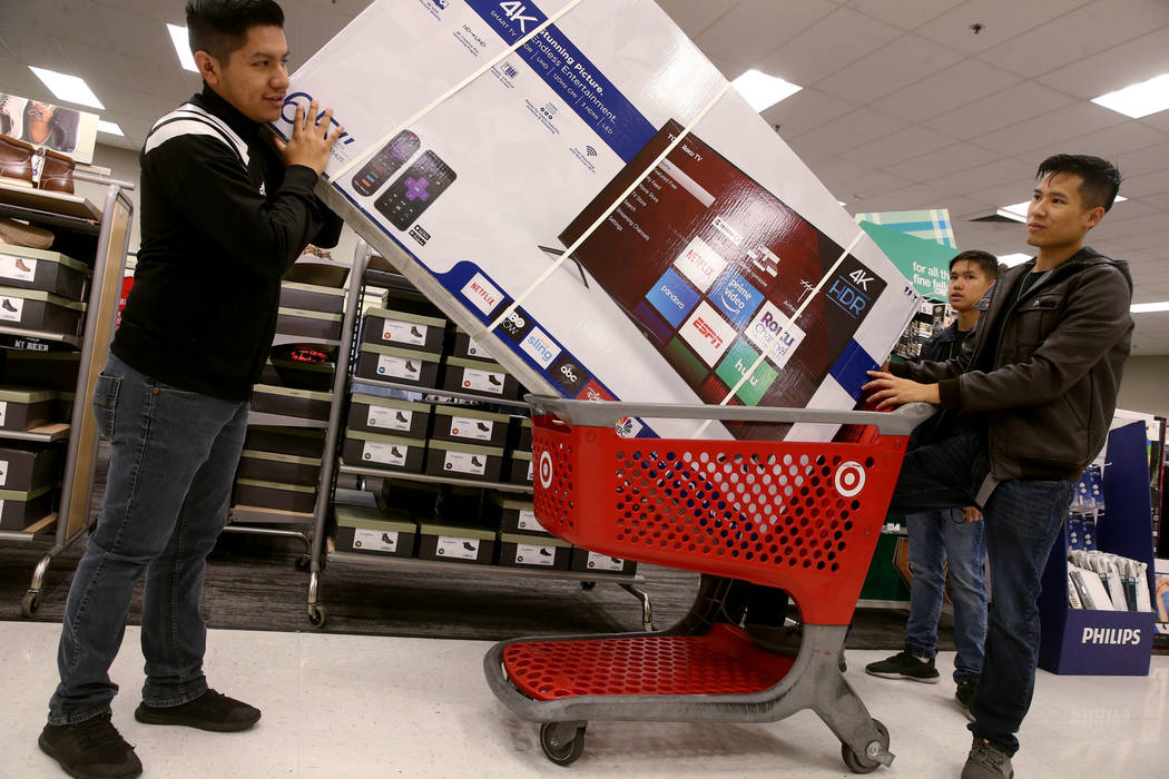 Juan Vazquez, Pat Hiranrak and his brother Ken Hiranrak, all of Las Vegas, load a 65-inch TV at ...