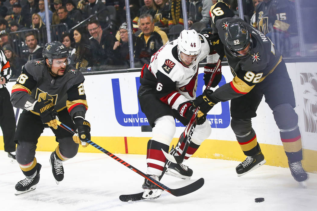 Golden Knights' Tomas Nosek (92) battles for the puck against Arizona Coyotes' Jakob Chychrun ( ...