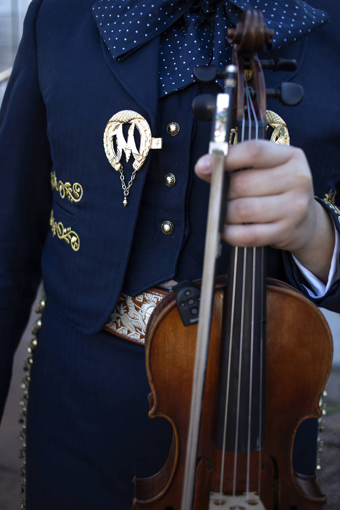 A member of Mariachi Herencia pauses before performing in her traditional mariachi garb at the ...