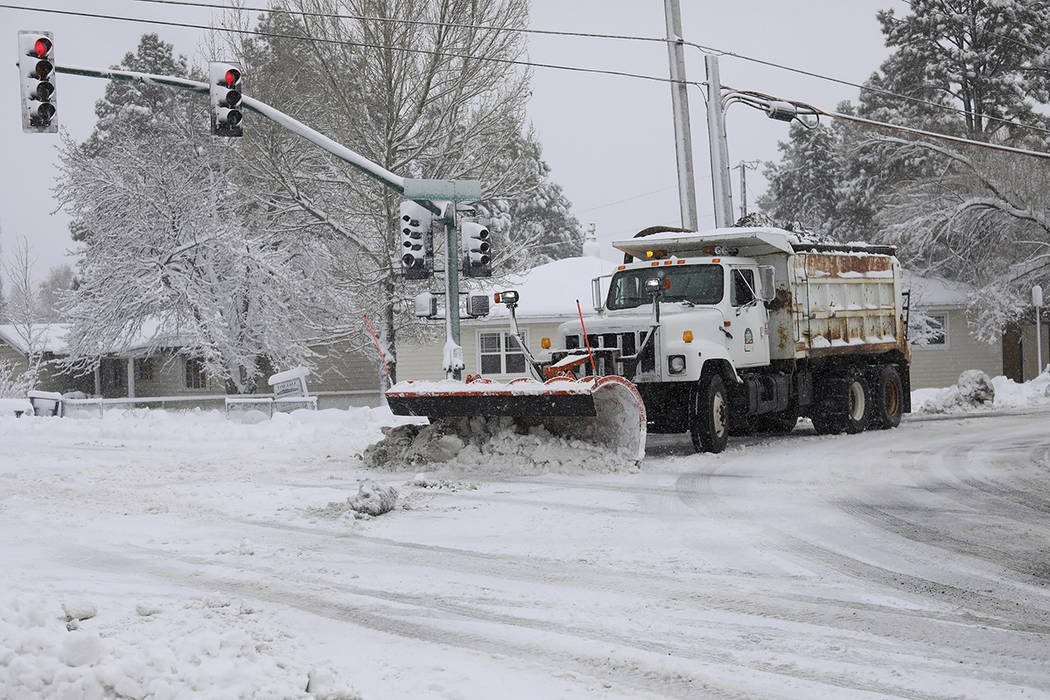 A city snowplow helps clear roads north of downtown Flagstaff, Ariz., Friday, Nov. 29, 2019. A ...