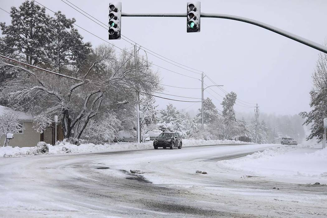 Commuters drive as the snow continues to fall north of downtown Flagstaff, Ariz., Friday, Nov. ...