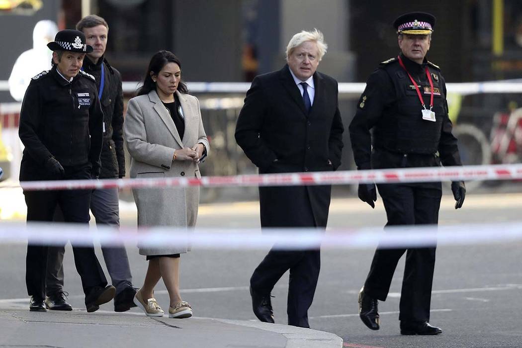 Britain's Prime Minister Boris Johnson, second right, Home Secretary Priti Patel, center, and M ...