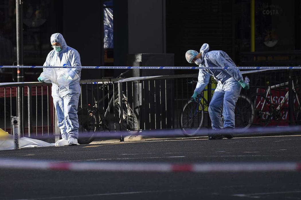 Forensic officers attend the scene in central London, Saturday, Nov. 30, 2019, after an attack ...