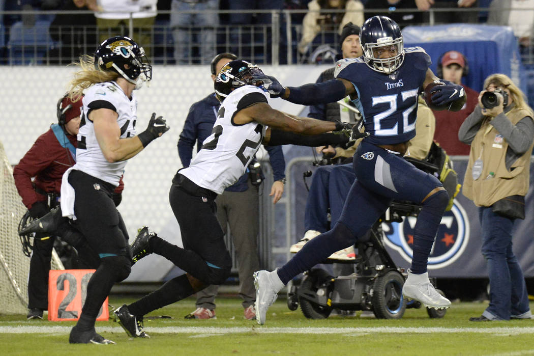Tennessee Titans running back Derrick Henry (22) runs past Jacksonville Jaguars safety Jarrod W ...