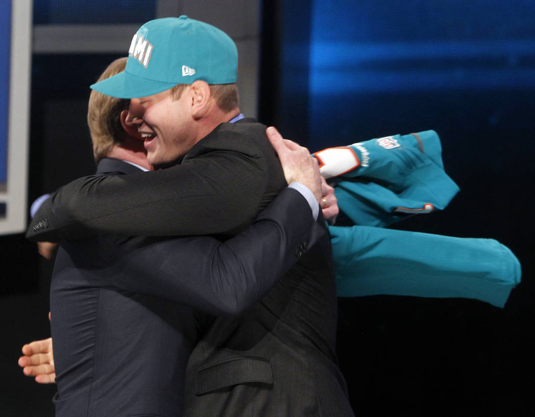 Texas A&M quarterback Ryan Tannehill, right, hugs NFL Commissioner Roger Goodell after bein ...