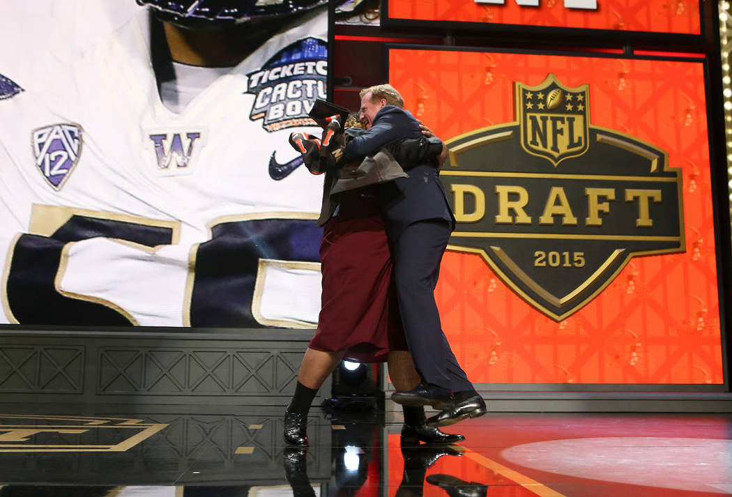 Washington defensive lineman Danny Shelton hugs NFL Commissioner Roger Goodell on stage after ...