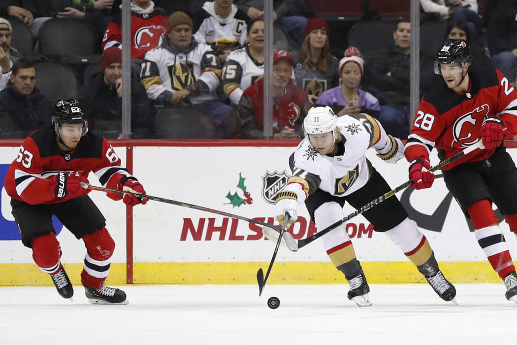 Vegas Golden Knights center William Karlsson (71) reaches for the puck as New Jersey Devils lef ...