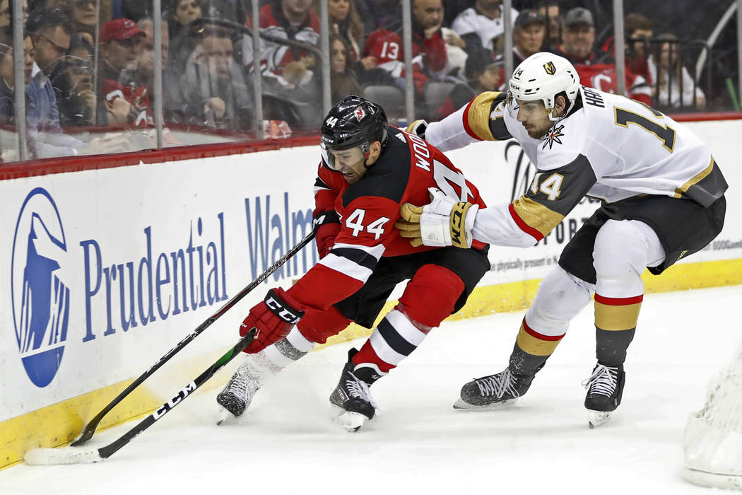 Vegas Golden Knights defenseman Nicolas Hague (14) gets his stick around New Jersey Devils left ...