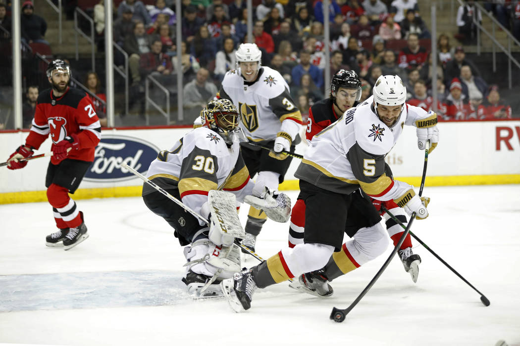 Vegas Golden Knights defenseman Deryk Engelland (5) tries to corral the puck away from New Jers ...