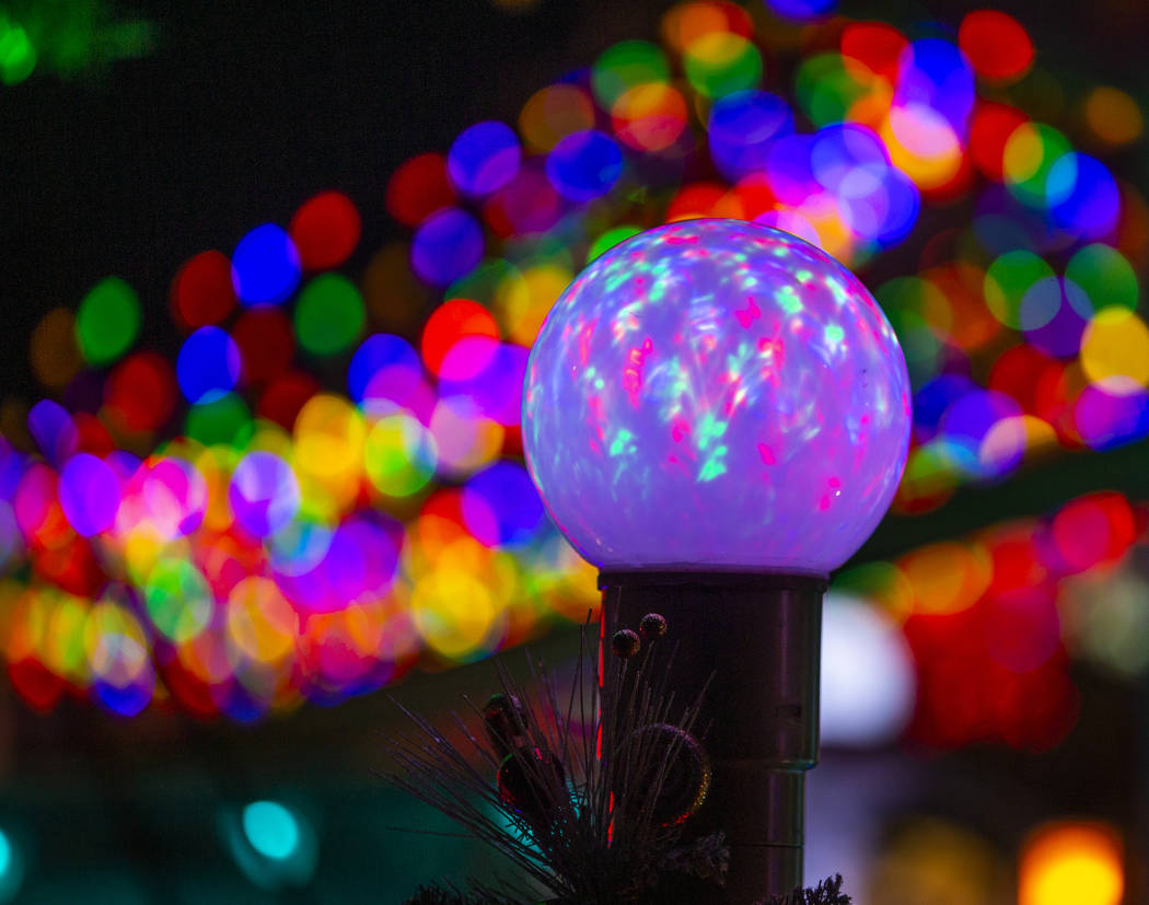 An illuminated globe as part of the holiday lights display in the yard of Maria and Juan Torres ...