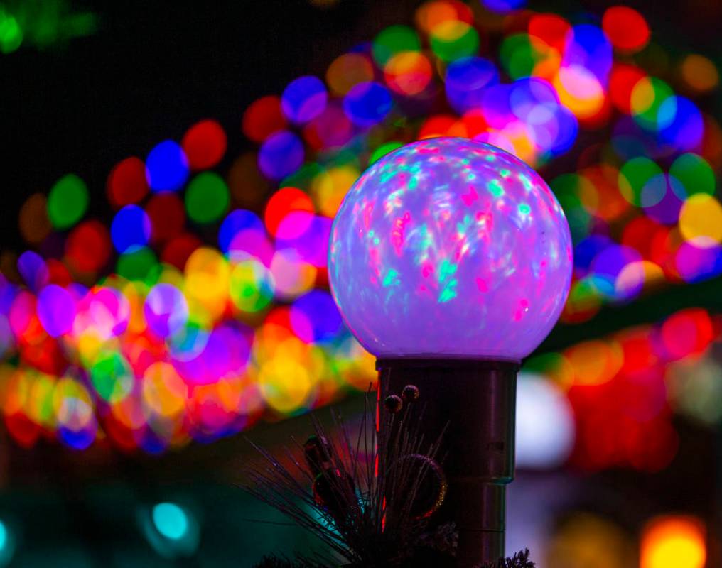 An illuminated globe as part of the holiday lights display in the yard of Maria and Juan Torres ...