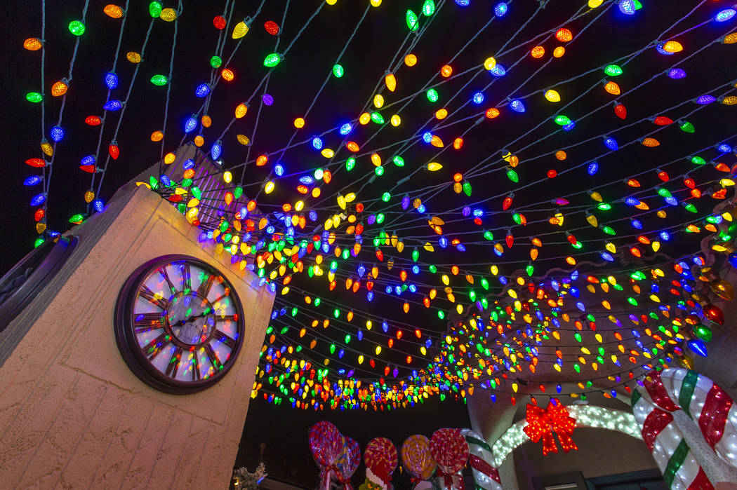 A clock tower and strings of lights as part of the holiday lights display in the yard of Maria ...