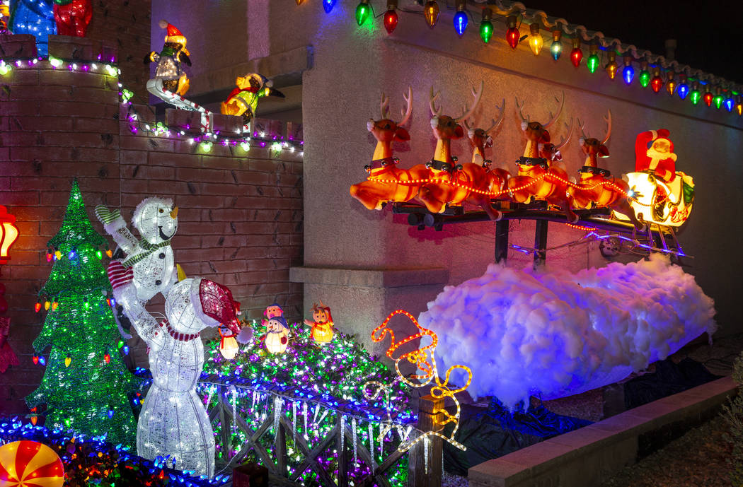Santa on his sleigh as part of the holiday lights display in the yard of Maria and Juan Torres, ...