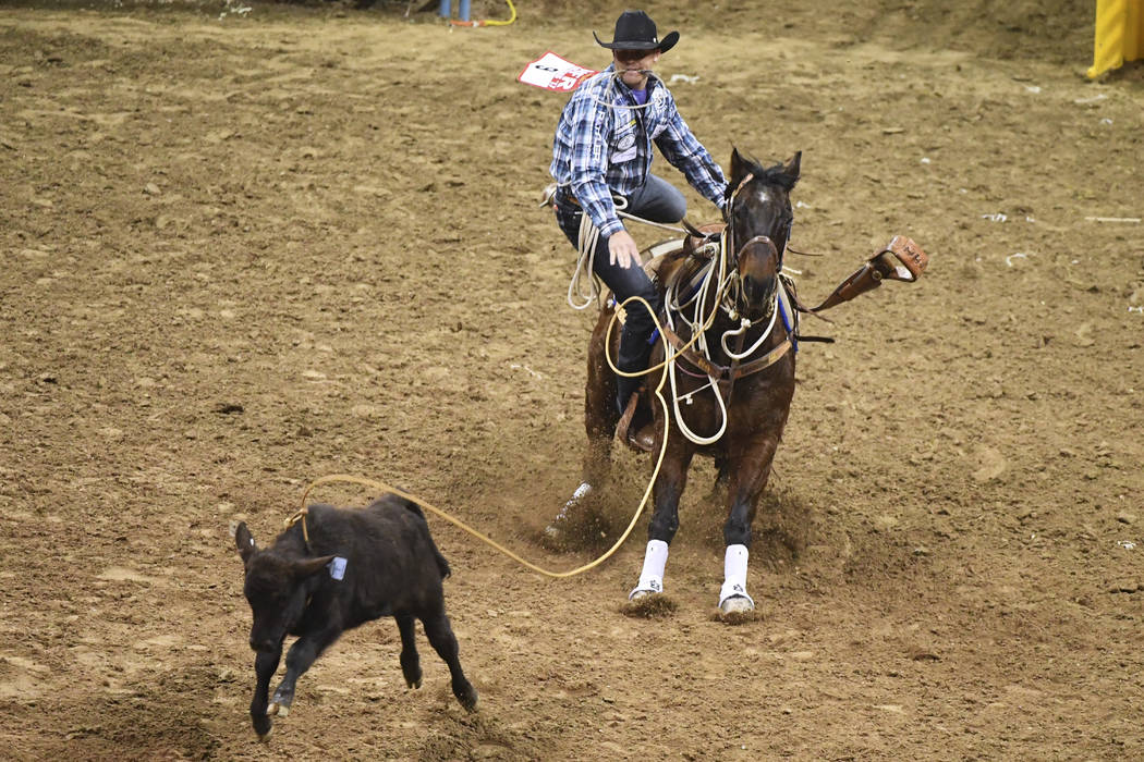 Caleb Smidt from Bellville, Texas, competes in tie-down roping during the first go-round of the ...