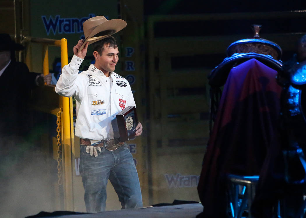 Clay Smith of Broken Bow, Okla. (22) walks up to be honored on stage after winning the Team Rop ...