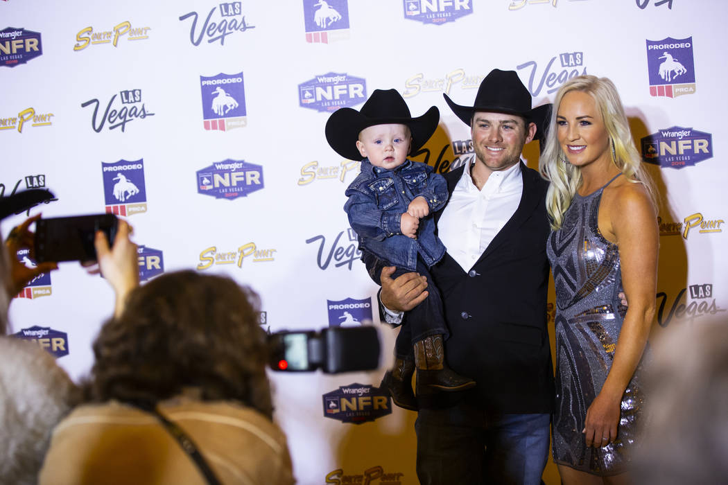 National Finals Rodeo contestant Tyler Wade, of Terrell, Texas, poses with son Weston, 1, and w ...