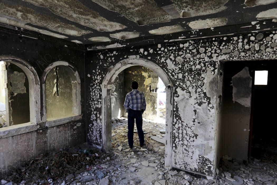 A former policeman walks through an abandoned home, torched by the Zetas cartel eight years bac ...