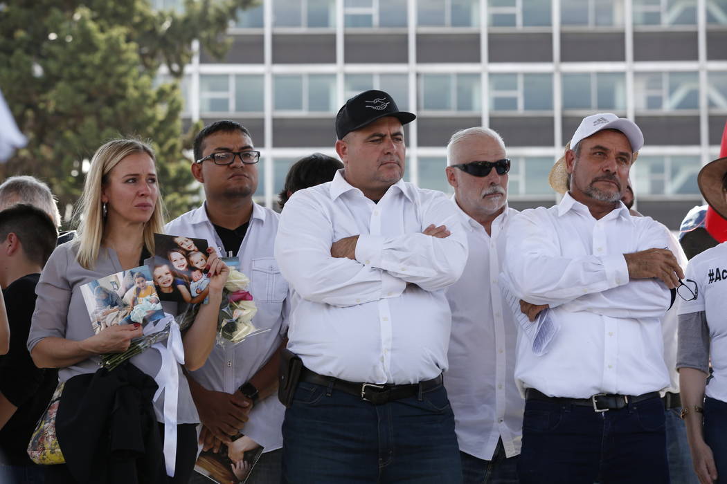 Adriana LeBaron, left, Julian LeBaron, center, and Adrian LeBaron, right, stand during a protes ...