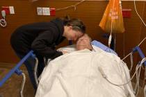 Lisa Light, left, leans over her father, Nevada State Sen. Keith Pickard, after Pickard was res ...