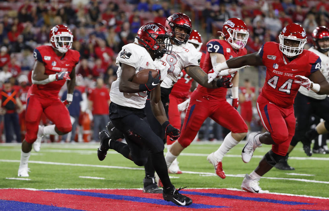 UNLV running back Charles Williams tries to get around Fresno State defensive lineman Leevel Ta ...