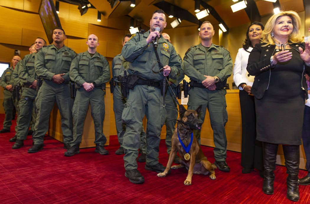 Las Vegas police K-9 officer Jason Dukes, center, with Hunter and other officers, speaks as the ...