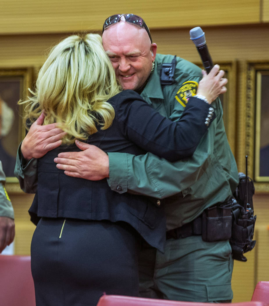 Las Vegas Mayor Pro Tem Michele Fiore, center, hugs Las Vegas police K-9 officer Jeff Corbett, ...