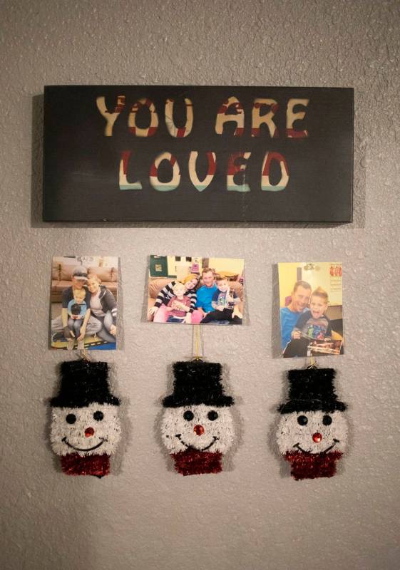 Family photos of Joan Williams, Dustin Huebner, and their sons John and Chase Huebner adorn the ...