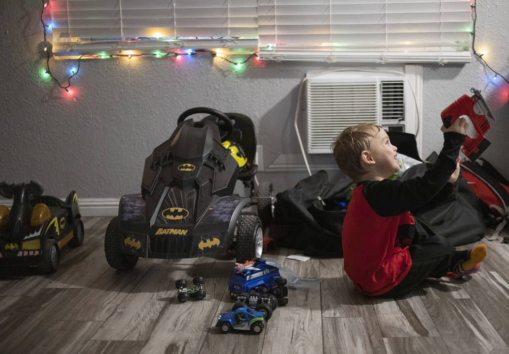 John Huebner, 2, plays with toys at his mom's new apartment on Saturday, Dec. 14, 2019, in Las ...